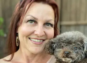 Woman holding a small dog outdoors