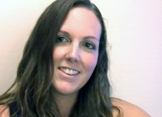 Woman with long dark hair against a plain background